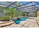 A screened-in pool area with a waterfall feature and lush landscaping at 626 Green Rock Ct, Apopka, FL 32712