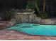 Beautiful screened pool featuring a rock waterfall, spa, and landscape lighting at 626 Green Rock Ct, Apopka, FL 32712