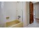 Bathroom featuring a yellow tub with tiled walls and shower, and a door to closet at 6411 Merriewood Dr, Orlando, FL 32818