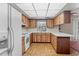 Kitchen features wood cabinets, white appliances, brick floors, and white countertops at 6411 Merriewood Dr, Orlando, FL 32818