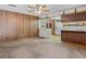 Spacious living room with carpet flooring flowing into the adjacent kitchen with wood cabinetry at 6411 Merriewood Dr, Orlando, FL 32818