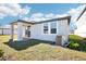 A view of the backyard showing the covered porch and grassy area of this modern home at 667 Pennywort St, Lake Alfred, FL 33850
