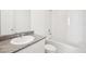 Bright bathroom features white tile, granite countertops, a shower-tub combo, and modern fixtures at 667 Pennywort St, Lake Alfred, FL 33850