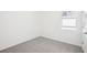 Bedroom features neutral carpet, a window with blinds, and fresh paint at 667 Pennywort St, Lake Alfred, FL 33850