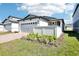 Beautiful front exterior with green lawn and landscaping, featuring a gray two-car garage at 667 Pennywort St, Lake Alfred, FL 33850