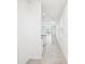 Hallway features white walls, tile floors, and leads to a bright living area with sliding glass doors at 667 Pennywort St, Lake Alfred, FL 33850