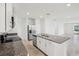 Kitchen island with granite countertop, stainless-steel sink, and white cabinetry at 667 Pennywort St, Lake Alfred, FL 33850
