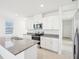 Bright kitchen features white cabinets, granite countertops, stainless steel appliances, and a center island with a sink at 667 Pennywort St, Lake Alfred, FL 33850