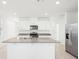 Bright kitchen with white cabinets, granite countertops, stainless steel appliances, and a center island with a sink at 667 Pennywort St, Lake Alfred, FL 33850