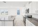 Bright kitchen features white cabinets, granite countertops, stainless steel appliances, and a center island with a sink at 667 Pennywort St, Lake Alfred, FL 33850