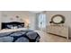 Comfortable bedroom featuring a plush bed, a decorative mirror, and soft carpeting, creating a cozy and inviting space at 7213 Nottingham Reel Ct, St Cloud, FL 34773