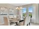Dining room with table set for six, chandelier, neutral paint, and large bright windows at 7213 Nottingham Reel Ct, St Cloud, FL 34773