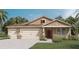 Charming single-story home showcasing a three-car garage, complemented by lush landscaping and a cozy front porch at 7213 Nottingham Reel Ct, St Cloud, FL 34773