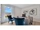 Bright home office with stylish blue velvet chairs, modern art, and a large window offering scenic neighborhood views at 7213 Nottingham Reel Ct, St Cloud, FL 34773