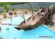Aerial view of pirate ship pool area including kiddie pool, waterslide, lounge chairs, and tropical landscape at 8101 Resort Village Dr # 31501, Orlando, FL 32821