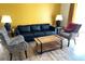 Living room featuring a black leather sofa, patterned armchairs, and a wood coffee table at 8101 Resort Village Dr # 31501, Orlando, FL 32821