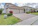 Attractive home with a three car garage, brick paver driveway, and manicured landscaping at 839 Timber Isle Dr, Orlando, FL 32828