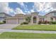 Inviting home with a three car garage, arched entry, and lush, green lawn at 839 Timber Isle Dr, Orlando, FL 32828