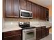 A kitchen is designed with stainless steel appliances and dark wood cabinets at 839 Timber Isle Dr, Orlando, FL 32828