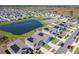 An aerial view of a community featuring modern homes with solar panels and a pond at 942 Jackson Ave, Davenport, FL 33837