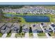 Community view of homes surrounding a lake, showcasing roofs with solar panels and manicured lawns at 942 Jackson Ave, Davenport, FL 33837