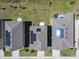This aerial view showcases neighborhood homes, each with solar panels on the roofs at 942 Jackson Ave, Davenport, FL 33837