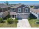 Charming two-story home with gray siding, manicured lawn, and a paved driveway leading to a garage at 942 Jackson Ave, Davenport, FL 33837