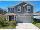 Two-story home with a two-car garage and cozy porch, highlighted by a well-maintained lawn at 942 Jackson Ave, Davenport, FL 33837