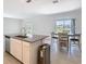 Open-concept kitchen featuring stainless steel appliances, an island with sink, and natural light at 942 Jackson Ave, Davenport, FL 33837