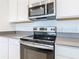 Modern kitchen with stainless steel oven, sleek countertops, and white cabinetry, for a stylish finish at 942 Jackson Ave, Davenport, FL 33837