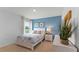 Bright bedroom with a blue accent wall, a white bed frame, and a view of the lush outdoors at 1028 Morfontaine St, Daytona Beach, FL 32124