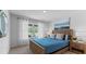 Cozy bedroom featuring a wooden bed frame, soft blue bedding, and a bright window with sheer curtains at 1028 Morfontaine St, Daytona Beach, FL 32124