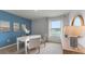 Bright home office with a blue accent wall, white desk, and a large window with natural light at 1028 Morfontaine St, Daytona Beach, FL 32124