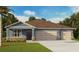 Charming one-story home featuring stone accents, a three-car garage, and a well-manicured lawn at 1044 Morfontaine St, Daytona Beach, FL 32124
