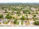 Aerial view features a vibrant community with an array of houses, tree-lined streets, and blue skies above at 1116 Adirondack St, Deltona, FL 32725
