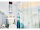 Bathroom featuring a toilet with wood storage shelf and mountain scene shower curtain at 1116 Adirondack St, Deltona, FL 32725