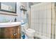 Cozy bathroom featuring a wooden vanity, toilet, and a shower with a striped curtain and blue painted walls at 1116 Adirondack St, Deltona, FL 32725