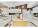 Functional kitchen featuring white cabinets, a kitchen island, and white appliances at 1116 Adirondack St, Deltona, FL 32725