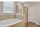 Luxurious bathroom featuring a soaking tub, stand up shower and wood-style flooring at 11968 Sands Cv, Orlando, FL 32828