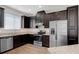 Modern kitchen with stainless steel appliances, dark cabinets, and granite countertops at 11968 Sands Cv, Orlando, FL 32828