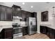 Well-equipped kitchen with stainless steel appliances, dark cabinets, and wood-look flooring at 11968 Sands Cv, Orlando, FL 32828