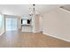 Bright and open-concept floor plan with wood-look tile flooring and a modern chandelier at 11968 Sands Cv, Orlando, FL 32828
