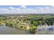 Expansive aerial view of lakeside homes, featuring lush greenery and serene lake access under a partly cloudy sky at 123 Tangelo Court, Maitland, FL 32751