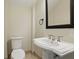 Charming powder room with pedestal sink, framed mirror, and neutral color palette at 123 Tangelo Court, Maitland, FL 32751