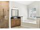 Open bathroom featuring double sinks, a soaking tub, glass shower, and large windows with natural light at 123 Tangelo Court, Maitland, FL 32751