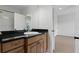 Bathroom featuring a vanity with dark granite countertop, wooden cabinets, and a well-lit mirror at 123 Tangelo Court, Maitland, FL 32751