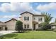 Charming two-story home boasts a manicured lawn, tile roof, and verdant landscaping at 123 Tangelo Court, Maitland, FL 32751