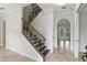 Bright foyer showcases a staircase with iron railings and travertine tile flooring at 123 Tangelo Court, Maitland, FL 32751