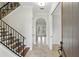 Elegant foyer featuring tile floors, a staircase with decorative iron railings, and a arched doorway at 123 Tangelo Court, Maitland, FL 32751