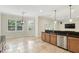 Kitchen with bar, stainless appliances, and stone flooring adjacent to breakfast nook with plantation shutters at 123 Tangelo Court, Maitland, FL 32751